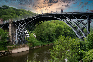 Fototapeta na wymiar The Iron Bridge is a cast iron arch bridge that crosses the River Severn in Shropshire, England. Opened in 1781, it was the first major bridge in the world to be made of cast iron. Sky added.