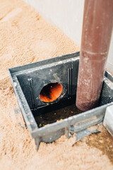 Fototapeta na wymiar Drainage system professional installation - drainage of rainwater from the roof into a pipe buried in the ground - sewage collector