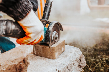 Bricklayer cuts stone with angle grinder - fast and safe - dust from power tools