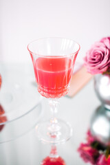 A glass of wine and rose petals