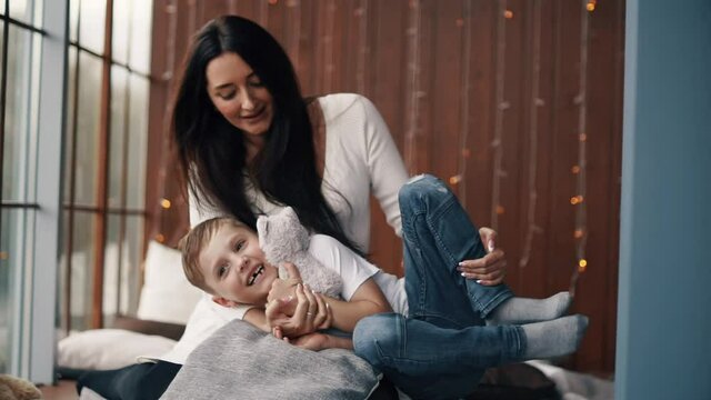 Mother sits with her child and plays with&nbsp;him.