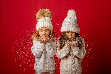 2 little girls on a red background blowing snow