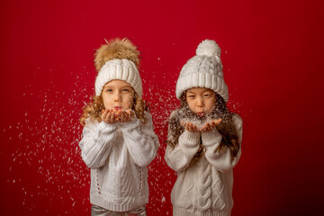 2 little girls on a red background blowing snow