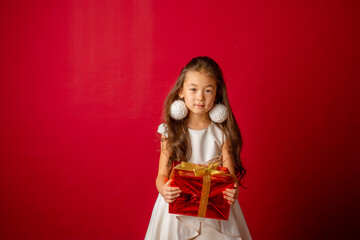 little asian girl new year on red background holding a gift