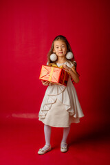little asian girl new year on red background holding a gift