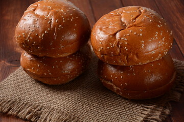 A stack of burger buns. Round bread on wooden board