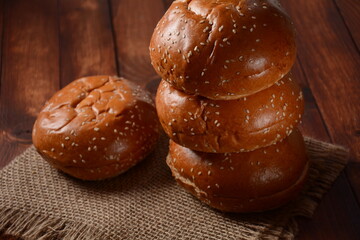 A stack of burger buns. Round bread on wooden board