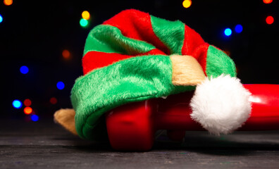Heavy green dumbbell with elf hat. Exercise equipment as a Christmas gift idea. Healthy fitness...