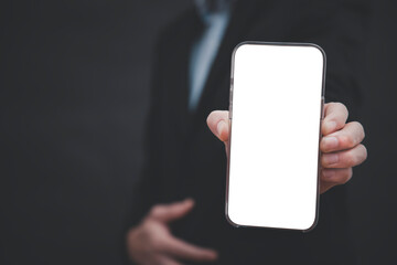 Businessman hand holding mobile white blank screen, Mock up cell mobile smart phone  in suit holds mobile phone with blank white screen on dark blue background,online business concept