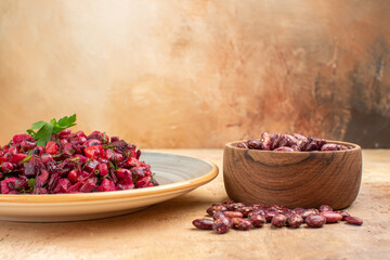 Side view of delicious salad with beetroot and bean and beans inside and outside of pot on mixed color background