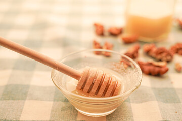 Honey with honey spoon and nuts in warm colors