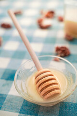 Honey spoon with honey on a blue tablecloth