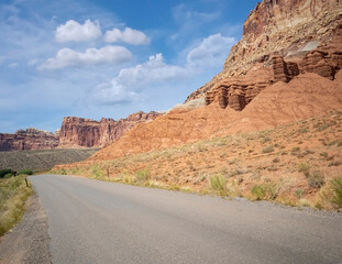 Sublime monoliths and towering sandstone cliffs on a hot partly cloudy summer day at Capitol Reef National Park in Southern Utah