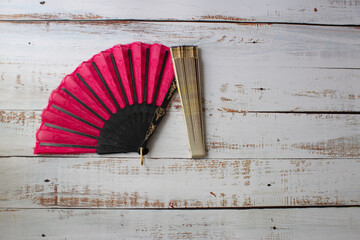 red open Spanish fan and yellow closed fan on white painted wood
