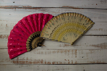 red and yellow spanish fans on a light wooden background