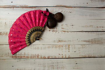 red spanish fan and castanets on a wooden background