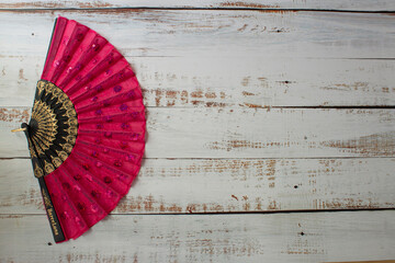 red spanish fan on a wooden background on the right side
