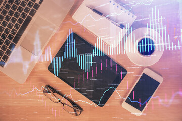 Multi exposure of forex graph hologram over desktop with phone. Top view. Mobile trade platform concept.