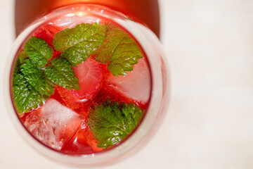 Summer refreshing cocktail with strawberries, ice and fresh mint leaves.