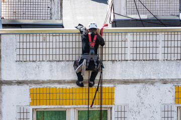 Industrial climber washes windows in high-rise building