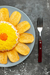 top close view of salad with chips with fork from right side on dark background