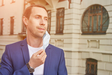 Man in protective face mask at city. Male person portrait. End lockdown concept. Sick...