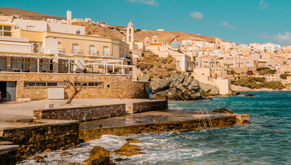 Stone beach in Ermoupolis on the islands of Syros, Cyclades, Greece with panorama view of the town in background