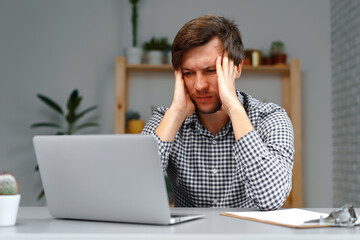 Young man working on laptop at his working table