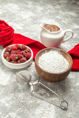 side close view of flour chocolate tea sieve and berries on focus with red napkin on side on marble background