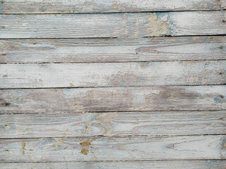 An ancient wooden background with peeling paint. The boards are blue. The boards are parallel. Texture. Background.