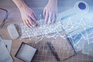 Multi exposure of man's hands typing over computer keyboard and forex graph hologram drawing. Top view. Financial markets concept.
