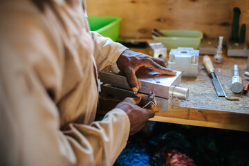 Hands of a man working with tools in a workshop in Uganda, Africa