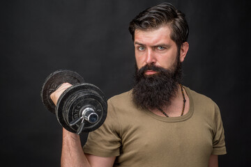 Fototapeta na wymiar Dumbbell. Bearded man with dumbbell. Bodybuilding. Sport. Sport equipment. Work out.
