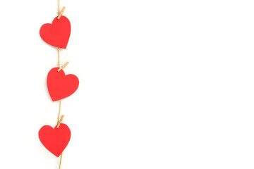 Corazones rojos de papel colgados de una cuerda sobre un fondo blanco liso y aislado. Vista de frente Copy space. Concepto: Día de San Valentín, matrimonio, día de la madre, concepto de amor.