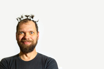 crazy man is very happy, strong human emotions, portrait of a bearded man with ponytails on his head on a white background