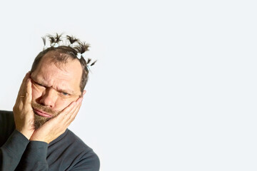 Obraz premium thoughtful man with a beard, strong human emotions, difficult choice, portrait of a bearded man with ponytails on his head on a white background