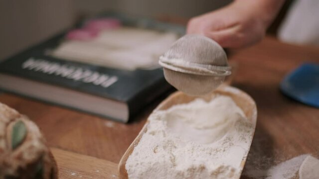 Person sifting flour with a sifter
