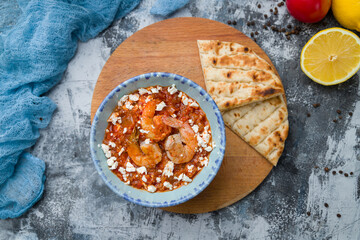 saganaki shrimp Greek cuisine on grey concrete table top view food
