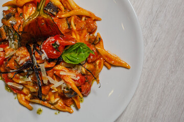 Pasta al sugo di pomodoro con pomodori freschi, melanzane fritte e formaggio