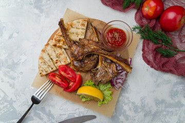 rack of lamb kebab with sause and pita on white concrete table, greek style kitchen © bbivirys