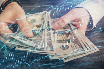 Multi exposure of financial graph drawing hologram and USA dollars bills and man hands. Analysis concept.