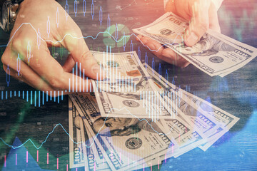 Multi exposure of financial graph drawing hologram and USA dollars bills and man hands. Analysis concept.