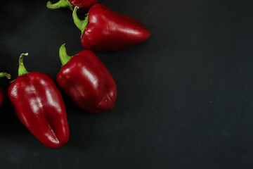 Red peppers on black background