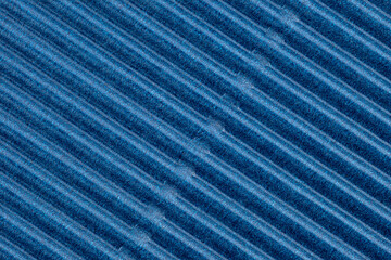 Background made of blue corrugated cardboard with diagonal stripes, view from above.