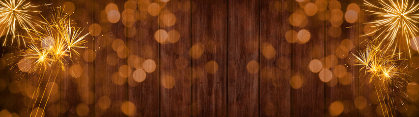 Silvester party New year background banner panorama long- Golden yellow Firework and bokeh lights on rustic brown wooden texture, with space for text