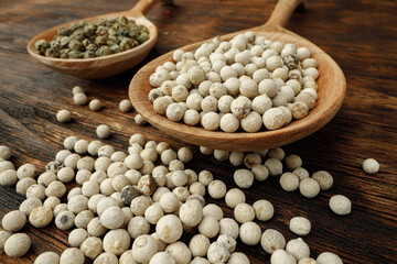 White peppercorn spice heap on wooden table