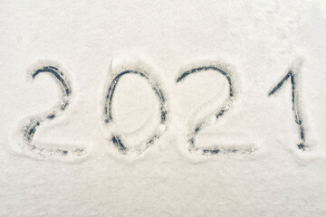 text 2021 written on fresh snow. symbol of the new year