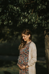 Beautiful pregnant girl wearing dress with flowers