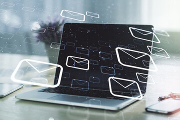 Double exposure of postal envelopes hologram on laptop background. Electronic mail and spam concept