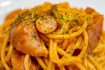 plate of basil powder put on a Pasta saute with  sausage and ketchup.